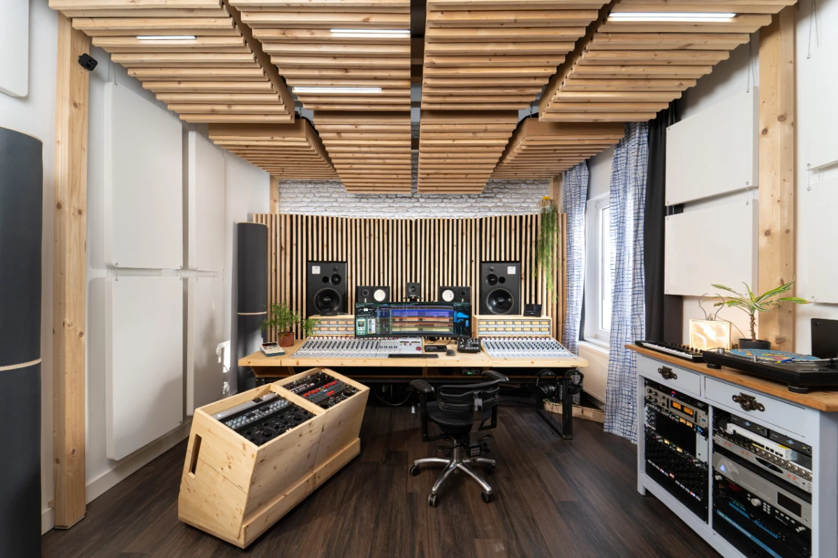 Regieraum eines Musikstudios mit Mischpult, Monitoren und akustischer Holzdecke