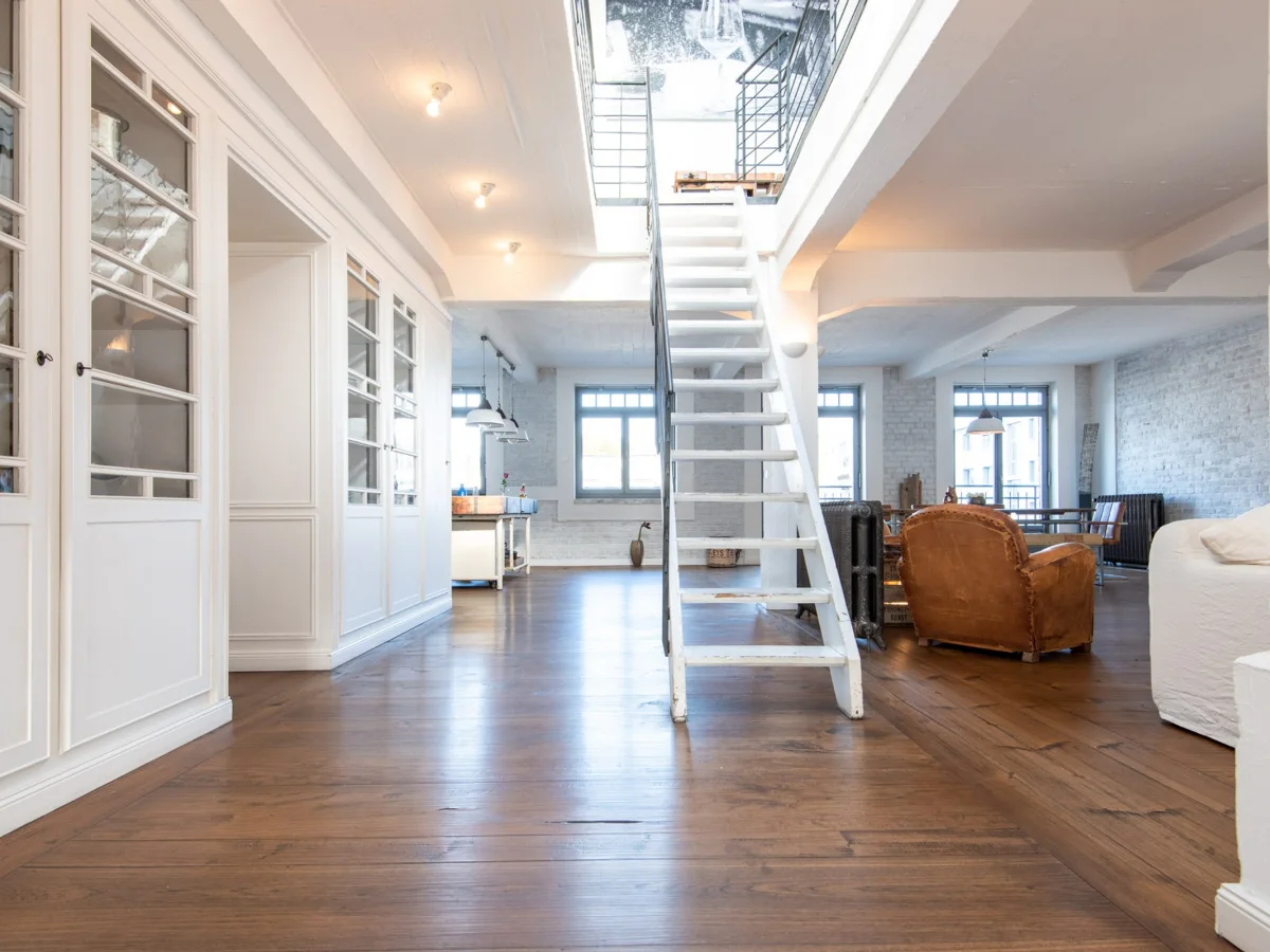 Heller Loftbereich im ROOFTOP LOFT in Düsseldorf mit Treppe und Holzfußboden